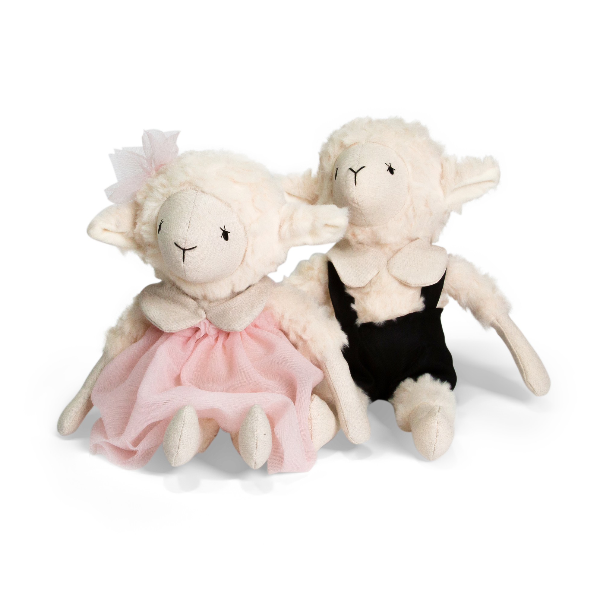Two plush lamb toys, one in a pink dress and the other in black overalls, on a white background.